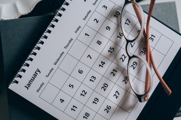 A calendar with a pair of glasses resting on it