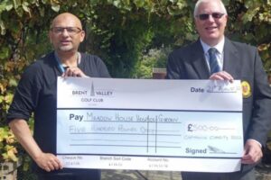 Two men holding up a large cheque