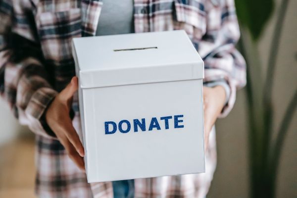 A person holding a donate box