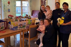 Staff and children around a table full of Easter eggs.