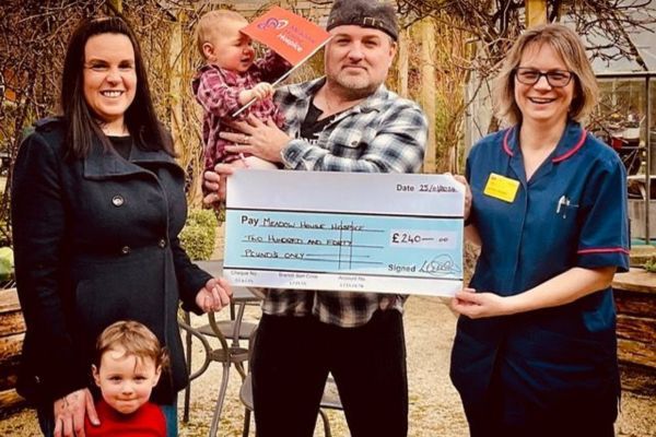 A family giving a member of staff a cheque.