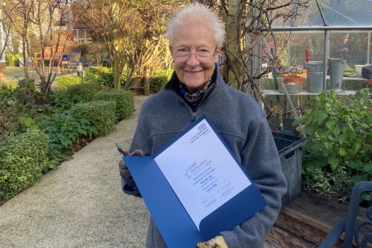 Gardener Carol, holding a certificate.