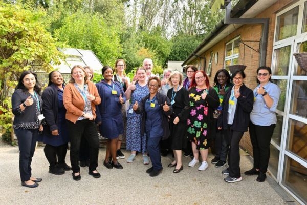 A group of meadow house hospice staff with their thumbs up