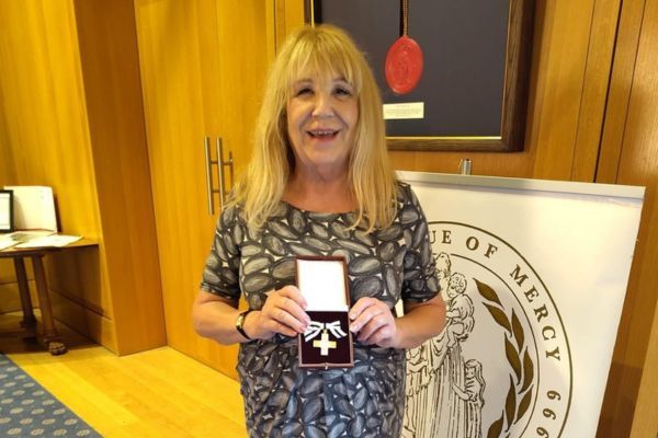 Pat proudly holding her award.
